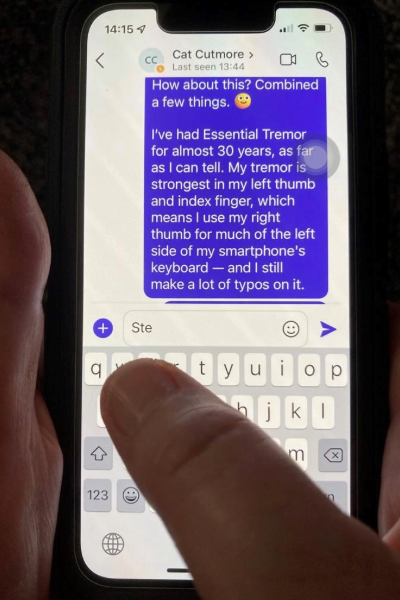 A right thumb tapping keys on the left side of an iPhone’s keyboard