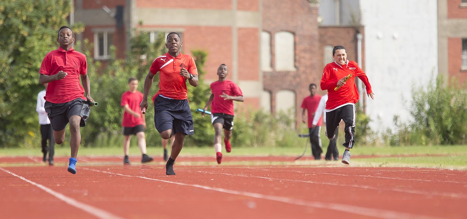 Boys running on a track towards the camera