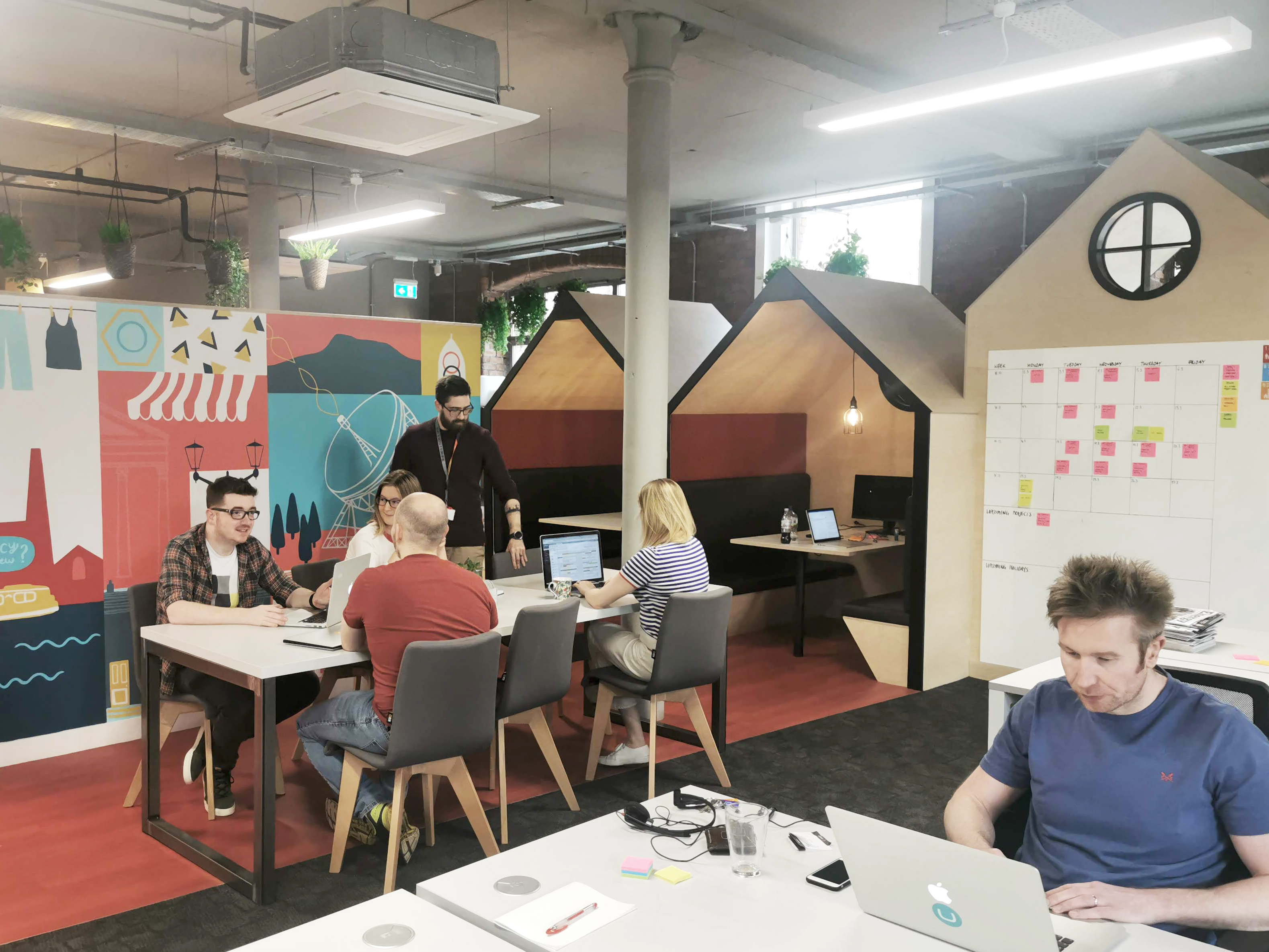 People sat around tables in the Macclesfield office