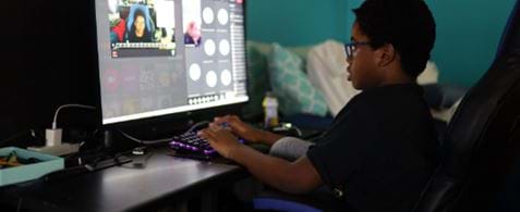Child using a keyboard looking at monitor