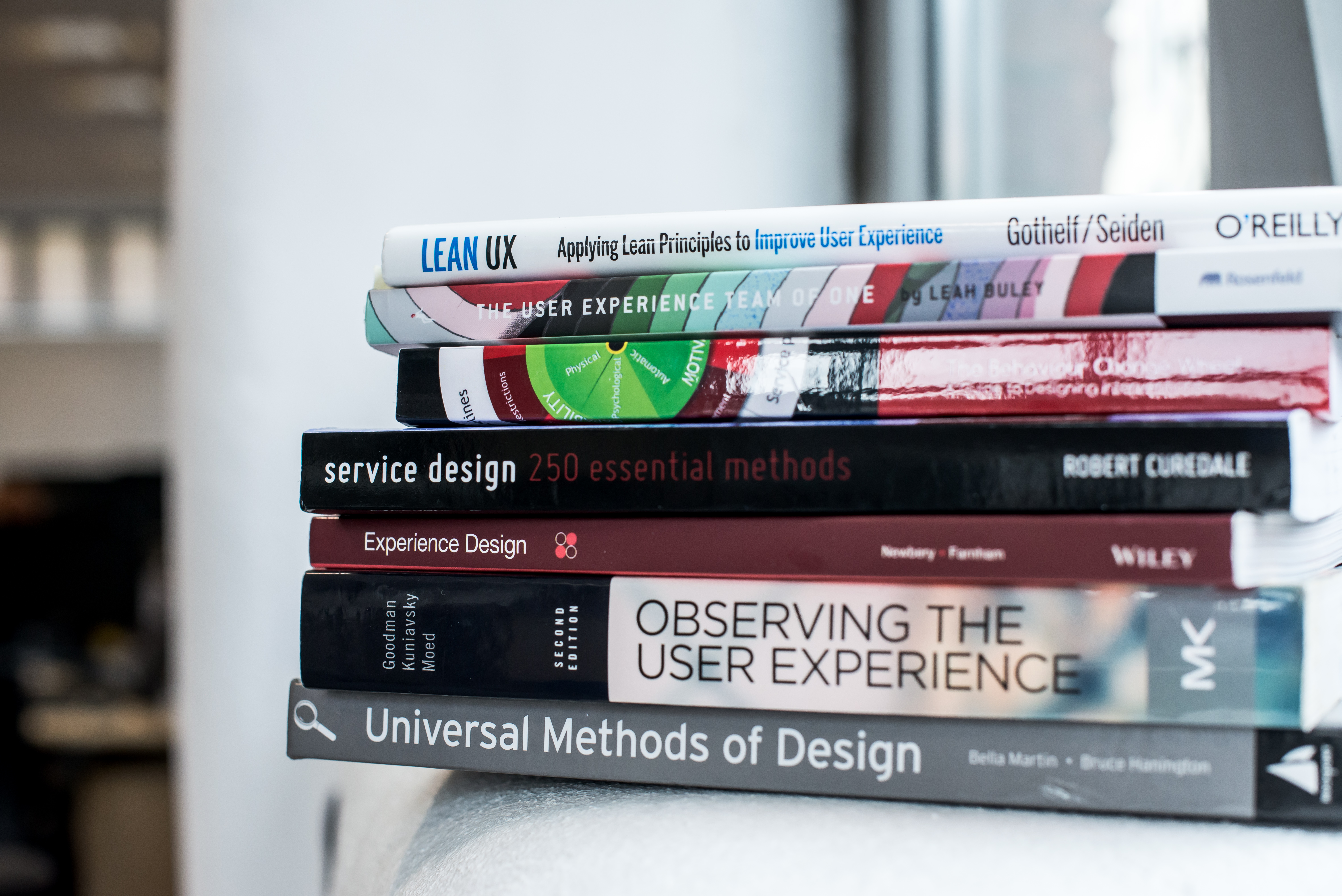 A stack of colourful user experience and service design books.