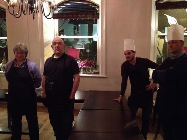 Four white people standing with chef hats on.
