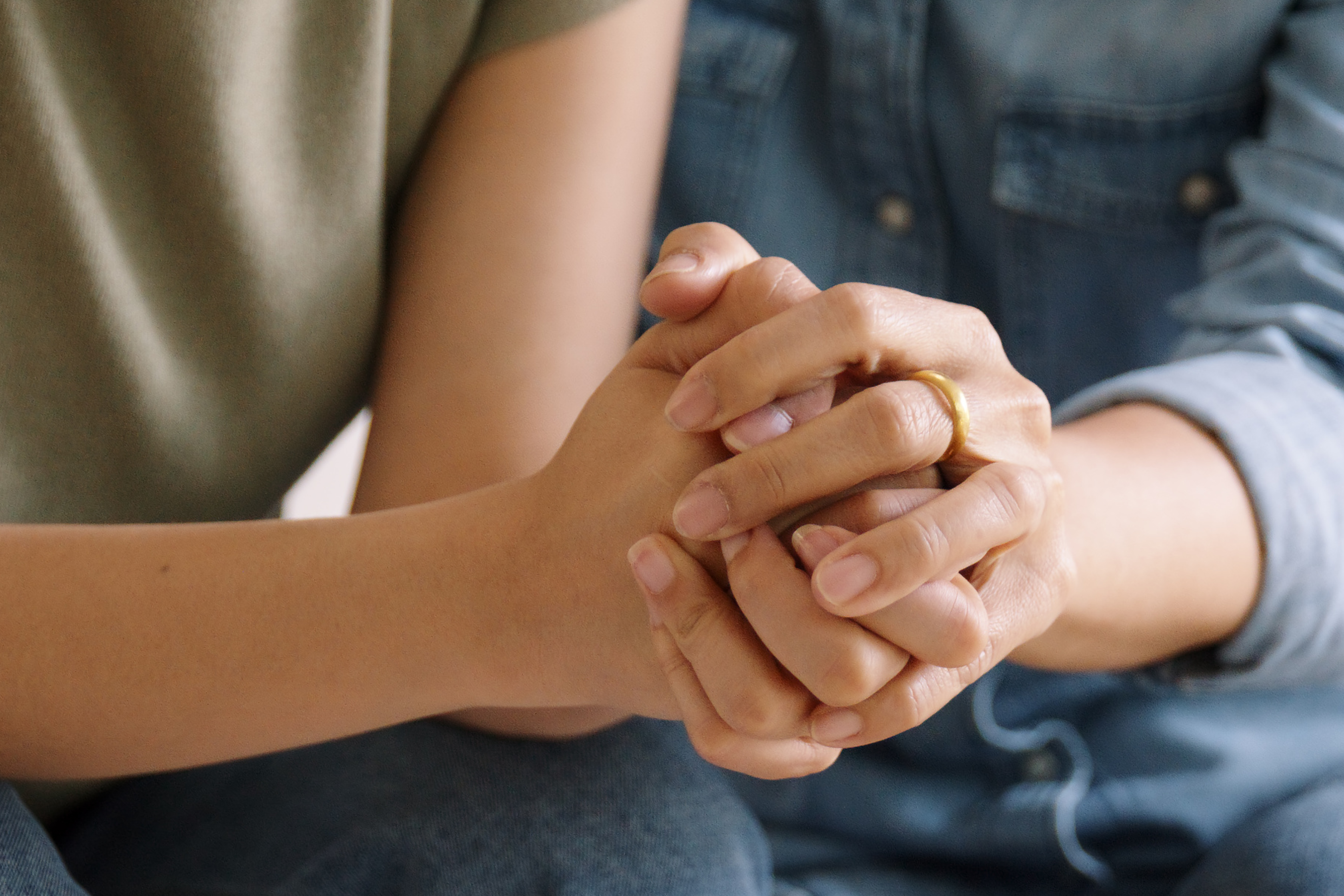 A person holding another's hands supportively