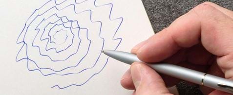 A hand drawing a jagged spiral, showing the effects of Essential Tremor.
