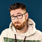 A headshot of Ross Jamieson, a white man with dark hair, glasses and raised eyebrows.