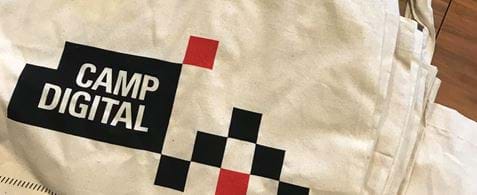 A stack of Camp Digital tote bags