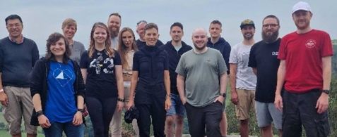 Codecabin attendees gathered in a group, standing on top of a hill