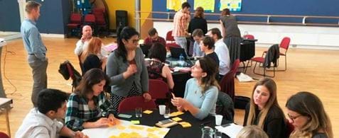 A group of people around a table with lots of post it notes.