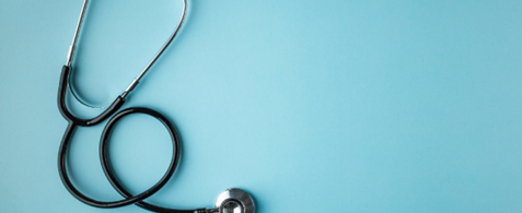 A coiled stethoscope on a blue background