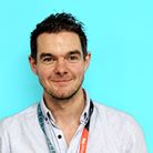 A headshot of Dave Brislane, a white man with brown hair and smiling.