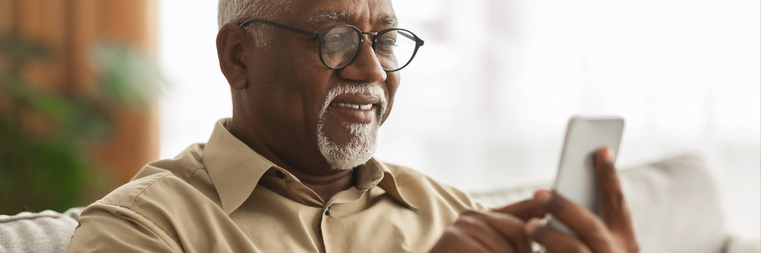 A older person using a smartphone and smiling at the screen