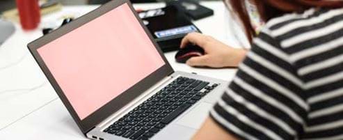 Person using a laptop on a desk in the office