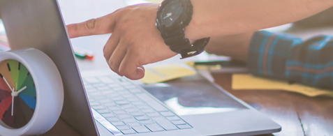 A hand pointing at the screen of a laptop