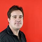 A headshot of Chris Bush, a white man with brown hair.